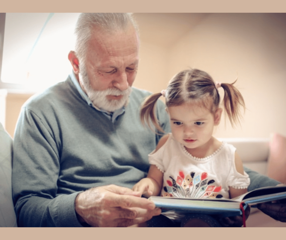 an elderly gentleman reading to a young girl