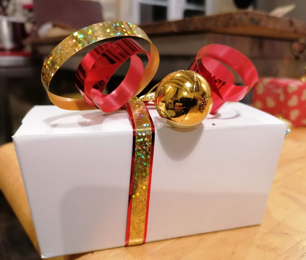 a gift box with a red ribbon tied to it