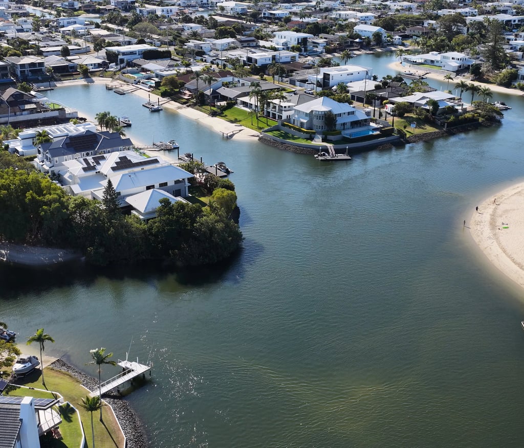 Aerial view of luxury waterfront real estate with private docks along a coastal canal.