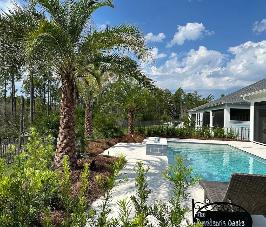 Luxury backyard swimming pool with palm trees, tropical landscaping, and a modern sun deck.