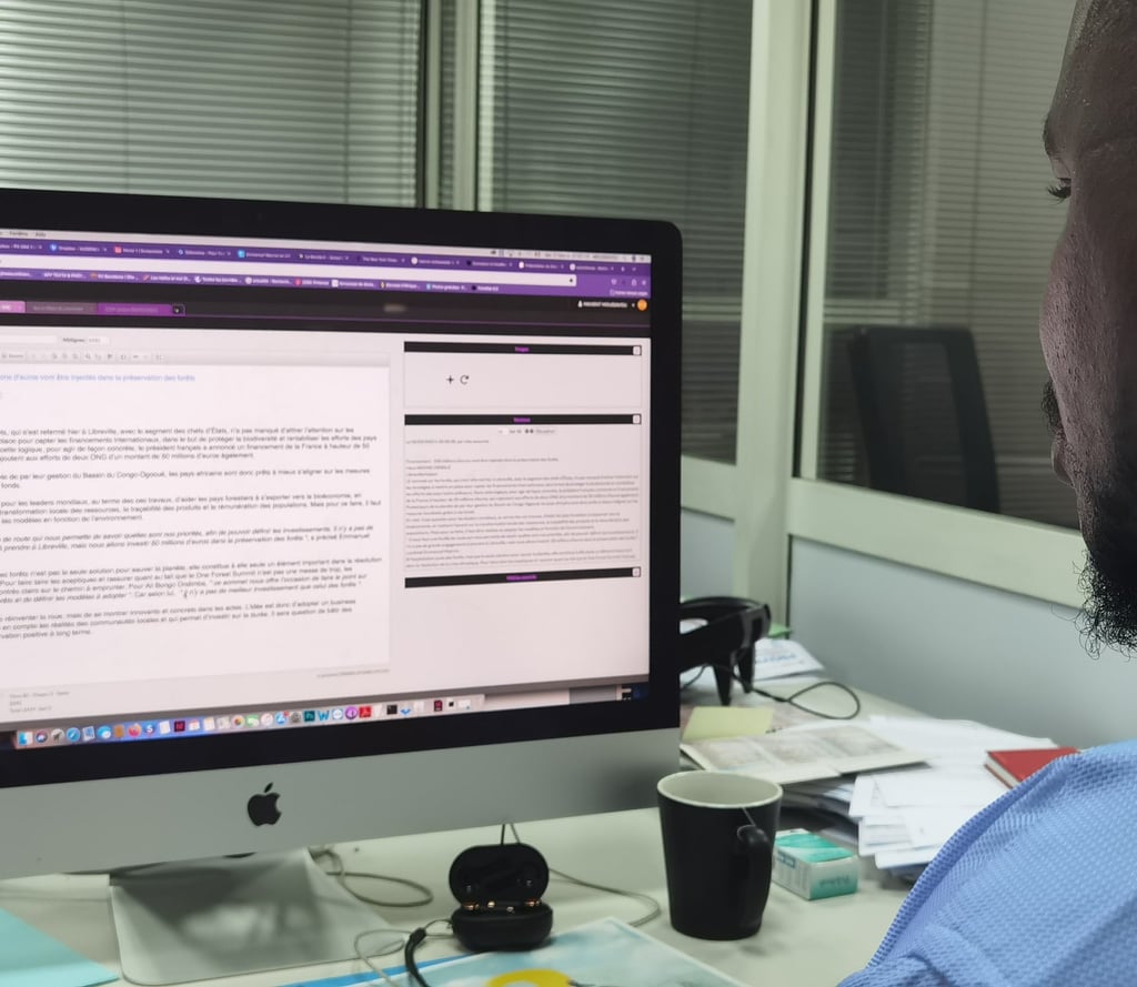 a man sitting at a desk with a computer monitor and a laptop