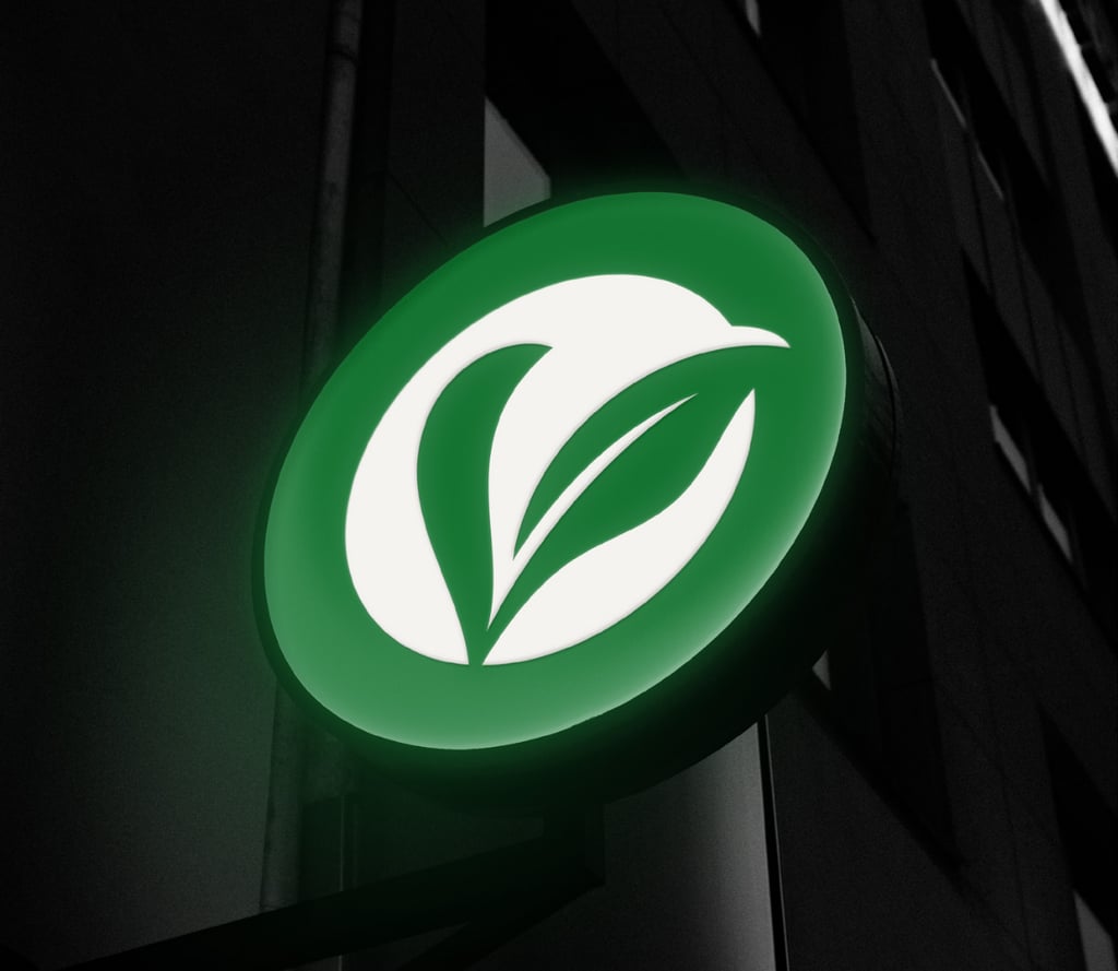 Un logo circulaire éclairé en vert et blanc avec un logo de feuilles sur une façade de bâtiment.