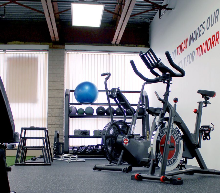 Modern home gym with air bikes, kettlebells, and fitness equipment for strength training.