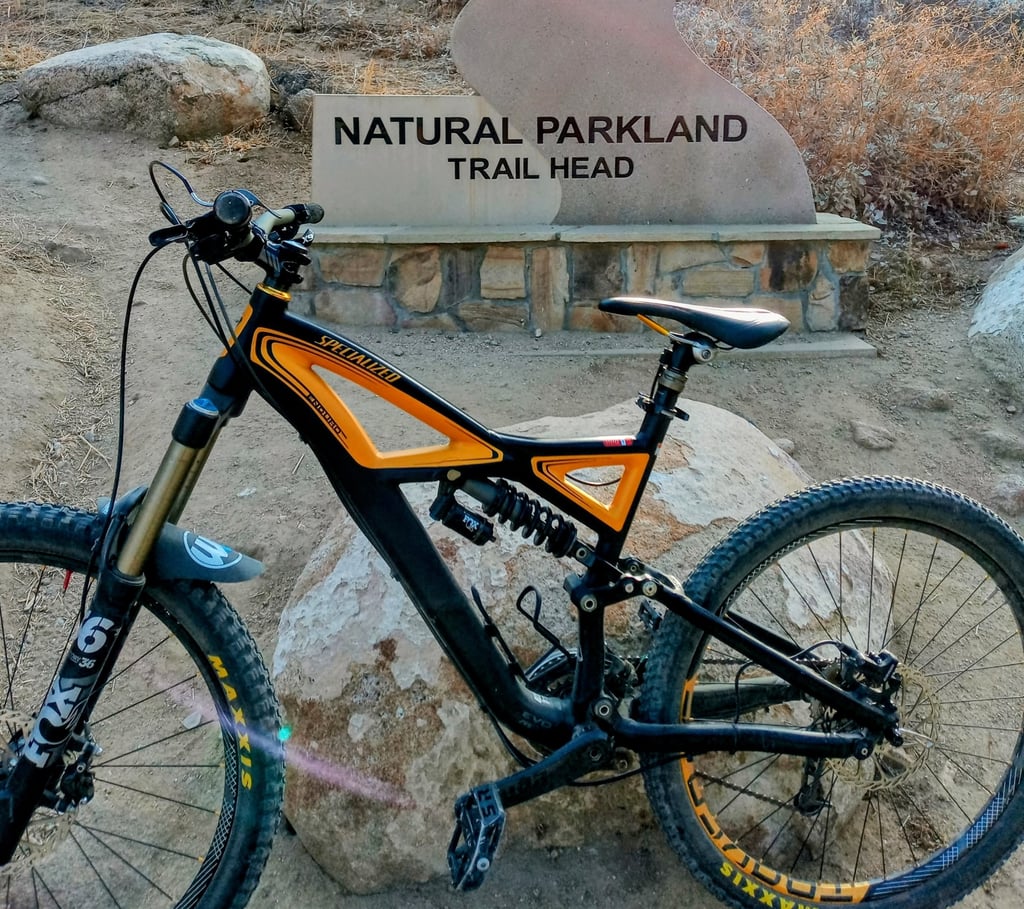 mountain bike parked in front of trail head