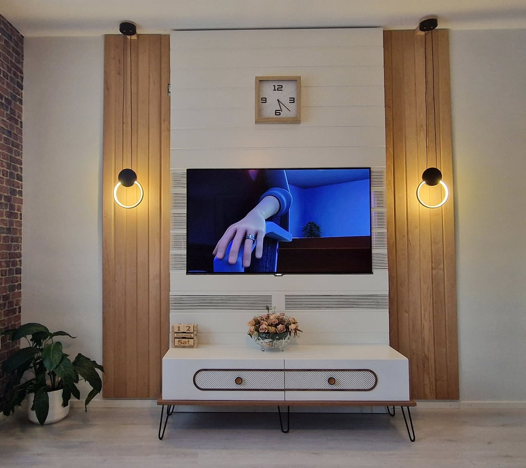 Modern living room TV wall unit with wood panels, circular LED lights, and white TV stand.