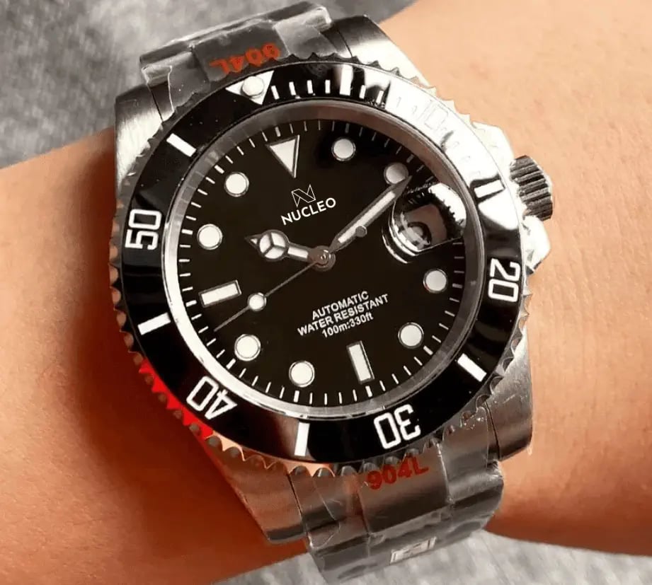 homage submariner acciaio quadrante e lunetta unidirezionale neri con data a ore 3 indossato al polso