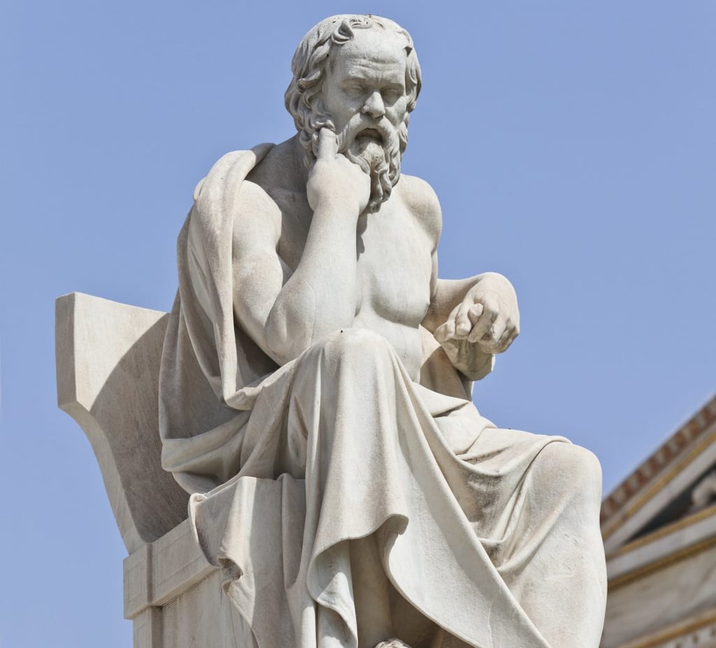a statue of Socrates sitting on a bench
