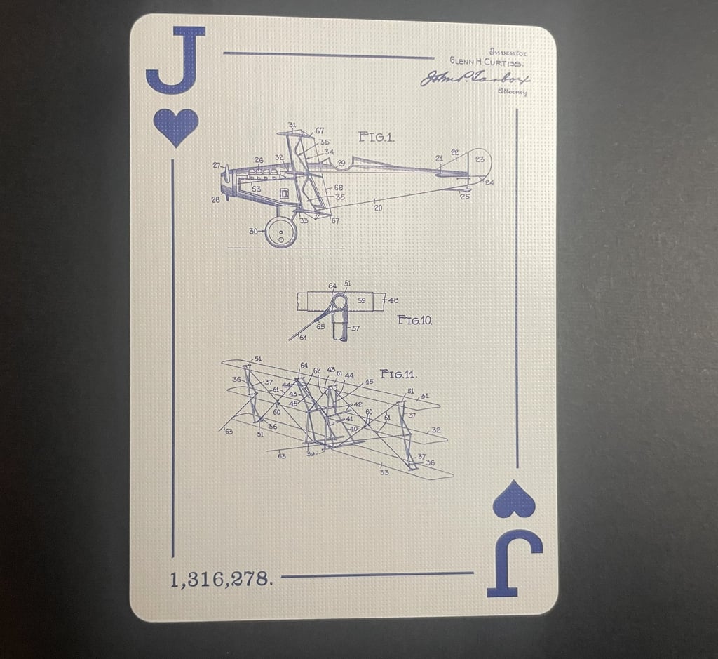 The Jack of Hearts facing up, displaying engineering drawings of a triplane from 1919