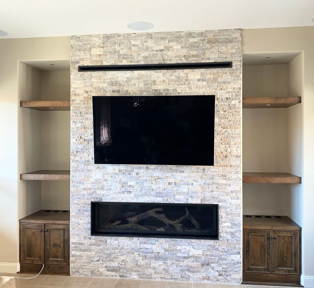 stone work fireplace surround with large mounted TV. Custom shelving on either side. Colorado Springs fireplace updates.