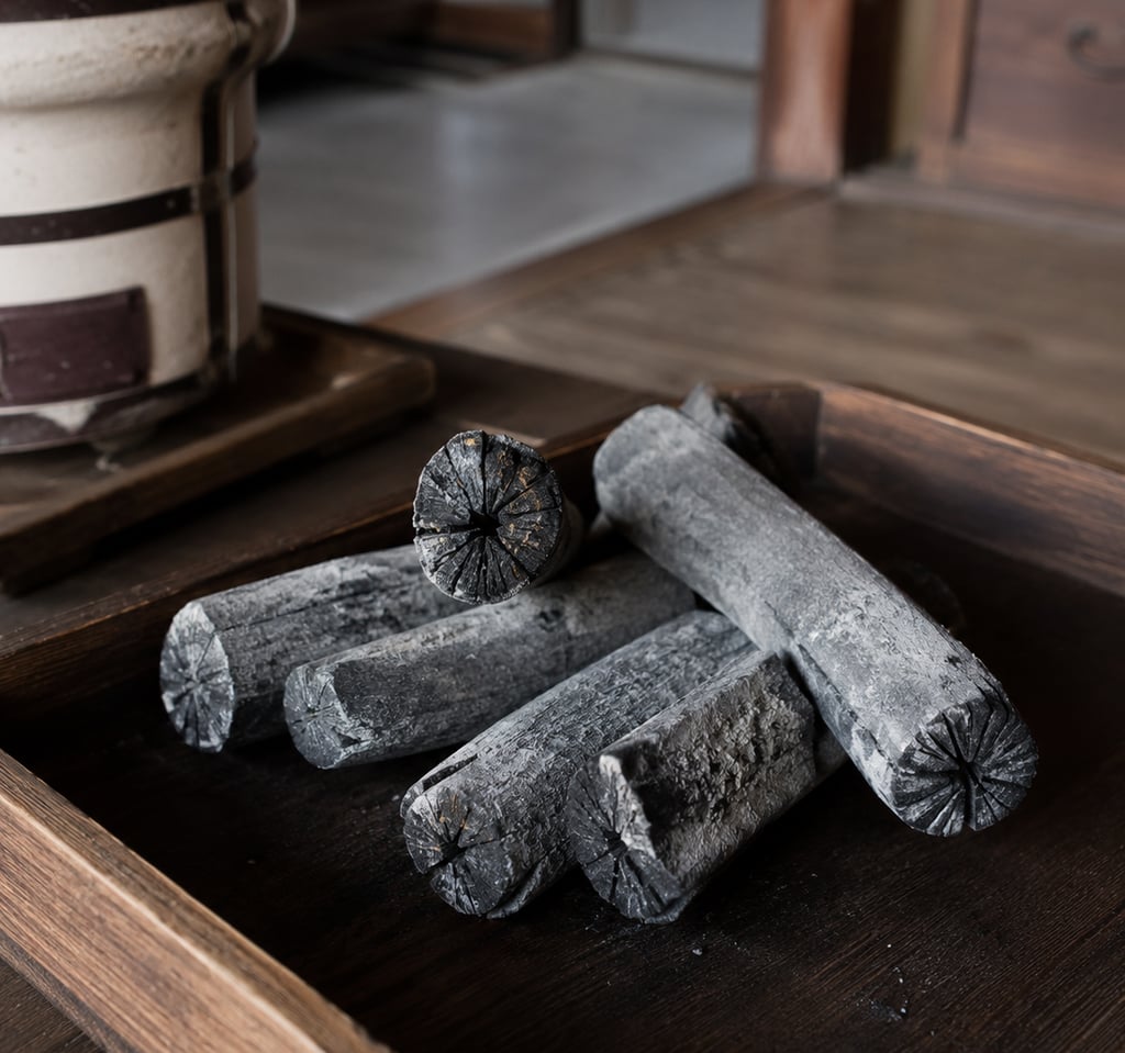 Traditional Japanese Bincho charcoal logs on a wooden tray for a Shichirin hibachi grill.
