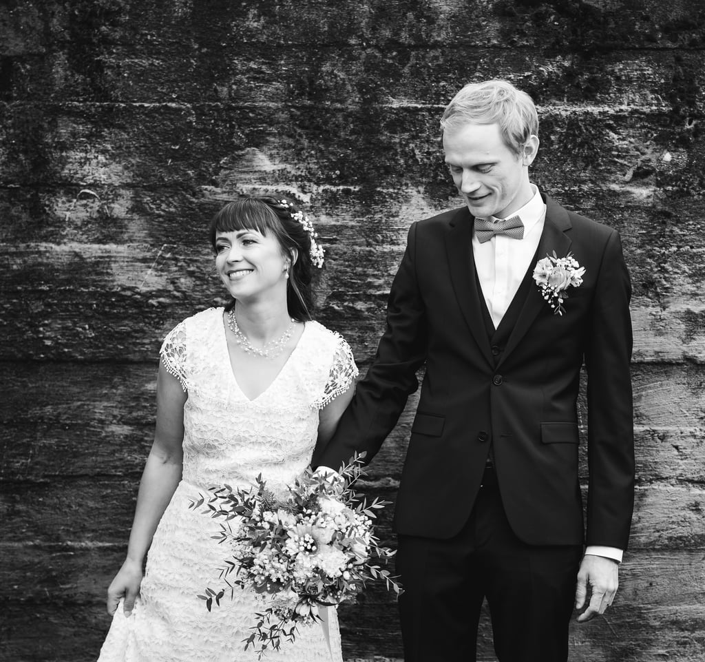 a bride and groom holding hands and smiling
