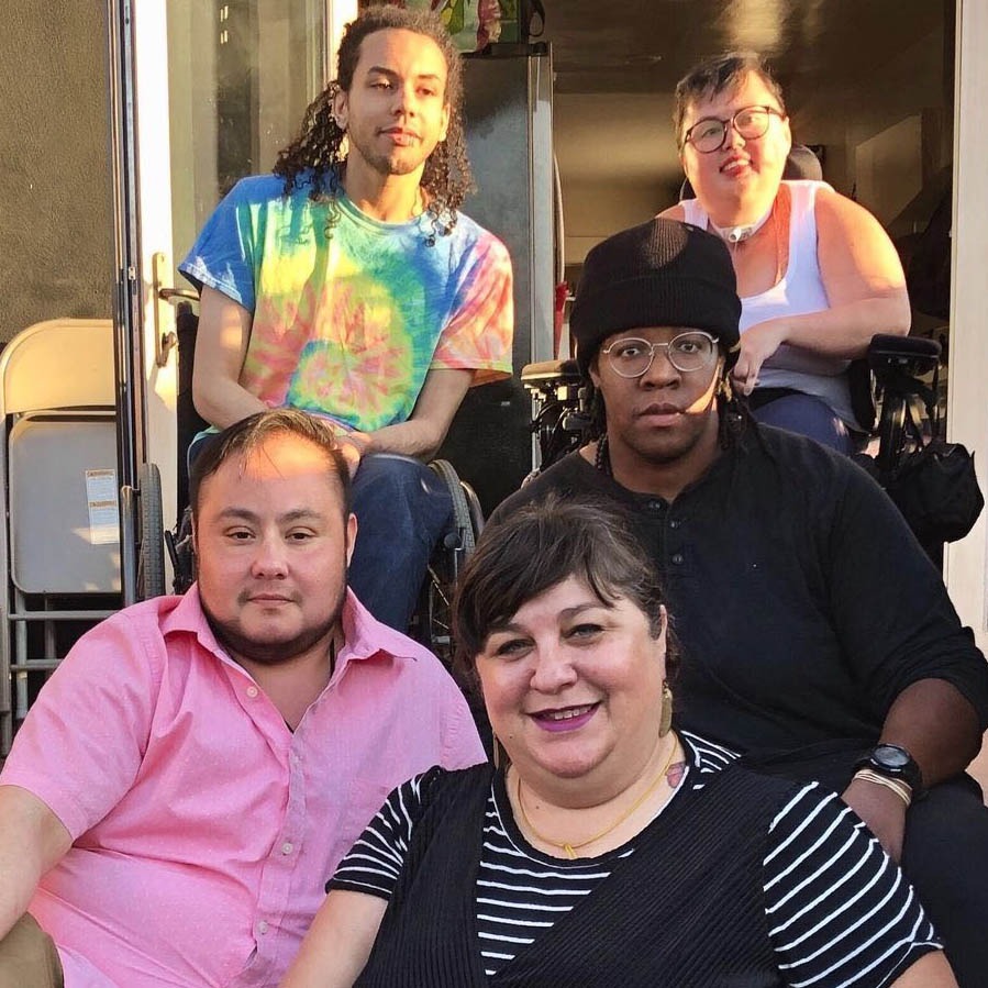 Photo of Stacey with members of DJCC sitting on stairs.