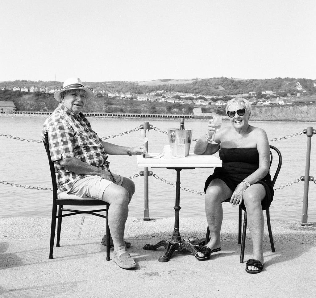 A retired couple in Folkestone enjoy some wine by the sea
