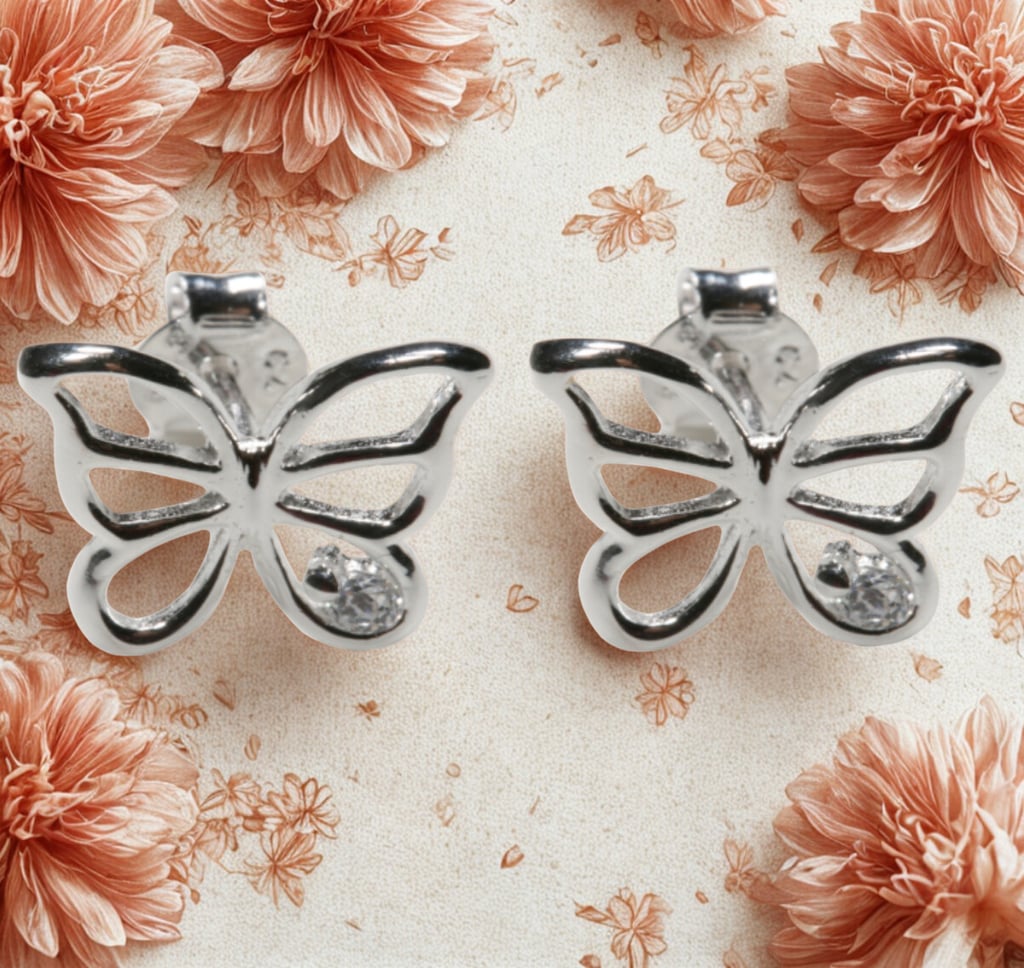 Elegant sterling silver butterfly stud earrings with sparkling cubic zirconia on a floral background.