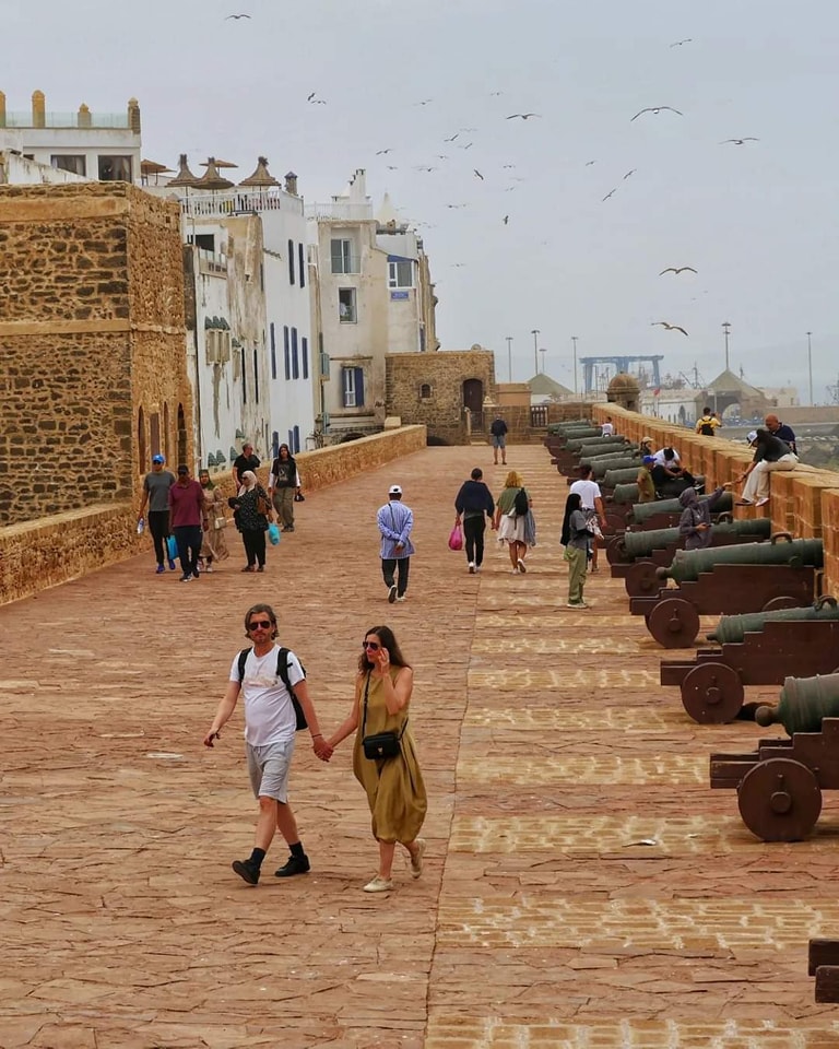 morocco a couple holding hands while walking down a path
