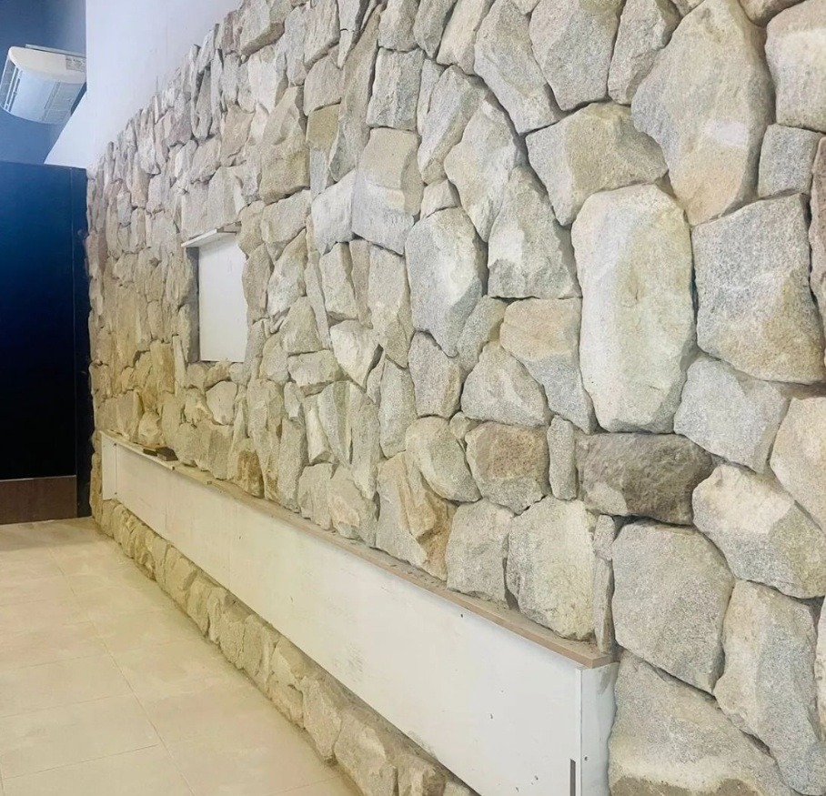 Pedra moledo branca, amarela, cinza caco almofadada irregular assentadea na parede interna e externa