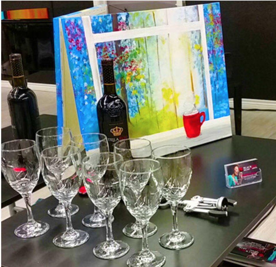 a table with wine glasses and canvas painting