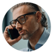 Headshot of a man wearing glasses on a mobile phone.