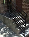 a white outdoor staircase with a handrail 