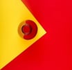 Pelota roja y amarilla en una esquina con fondo amarillo y rojo