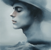a man in a hat over waves