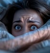 individu sous les couvertures yeux ouverts évoquant des troubles du sommeil