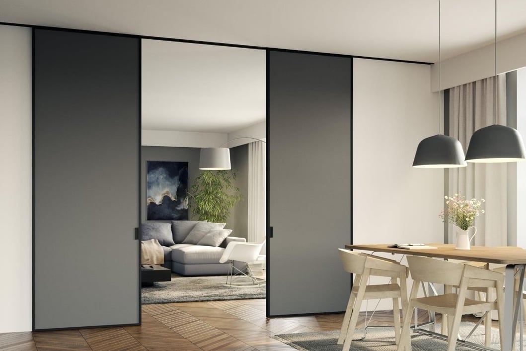 Puerta corredera acristalada con marco negro separando cocina y salón con diseño escandinavo