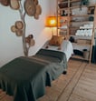 a massagebed with pillows and a shelf with baskets