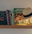 a hat on a shelf with books and a hat