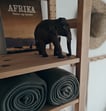 a toy elephant standing on a shelf with towels and towels