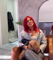 a woman with red hair and a dog sitting on a couch