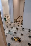 In-progress subfloor leveling installation using adjustable pedestal system during interior renovation
