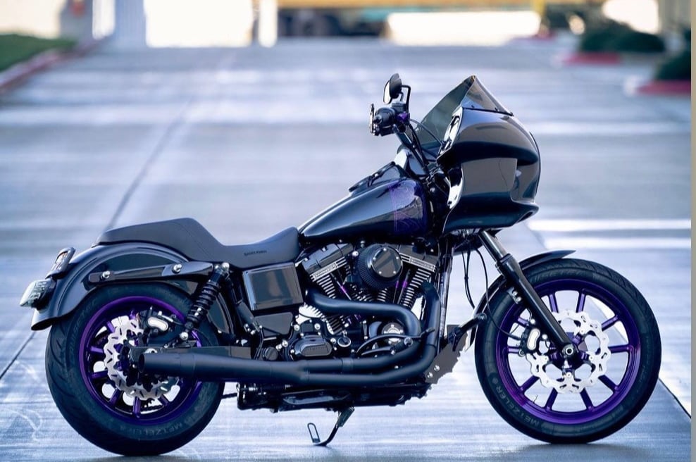 black motorcycle with purple accents parked on a street