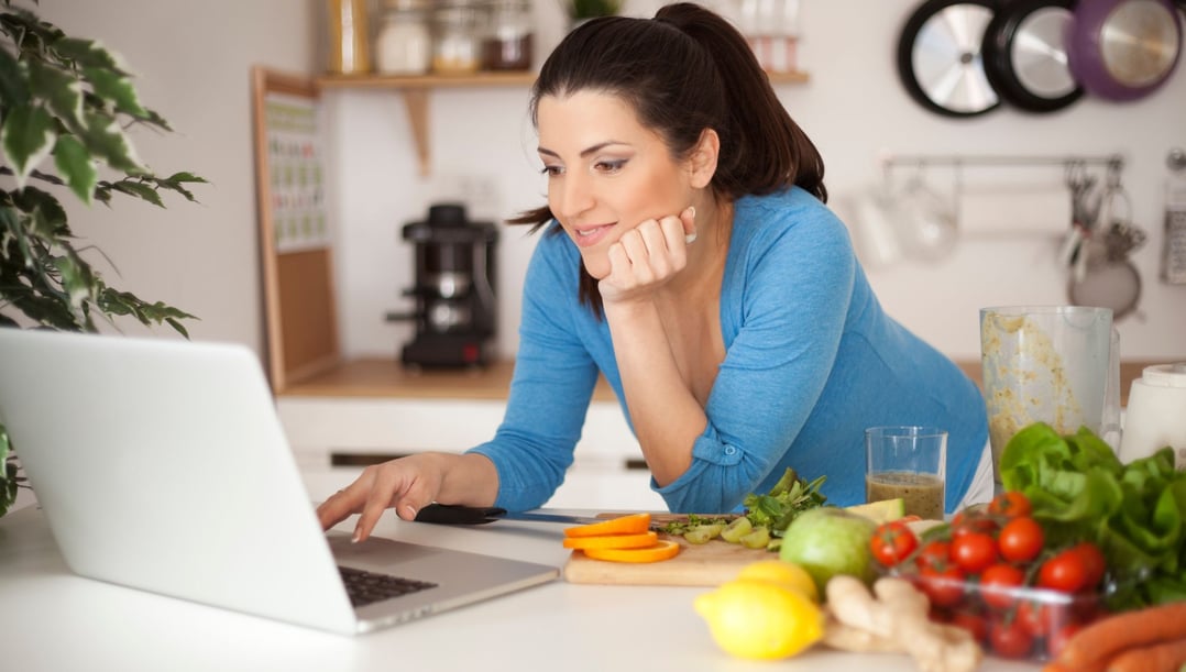 a woman is sitting at a table with a laptop