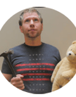 a man looking up holding a hammer and a teddy bear