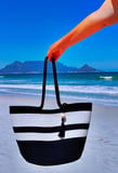 a person holding a black and white striped bag