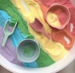 a bowl of colored sand with a spoon and spoon