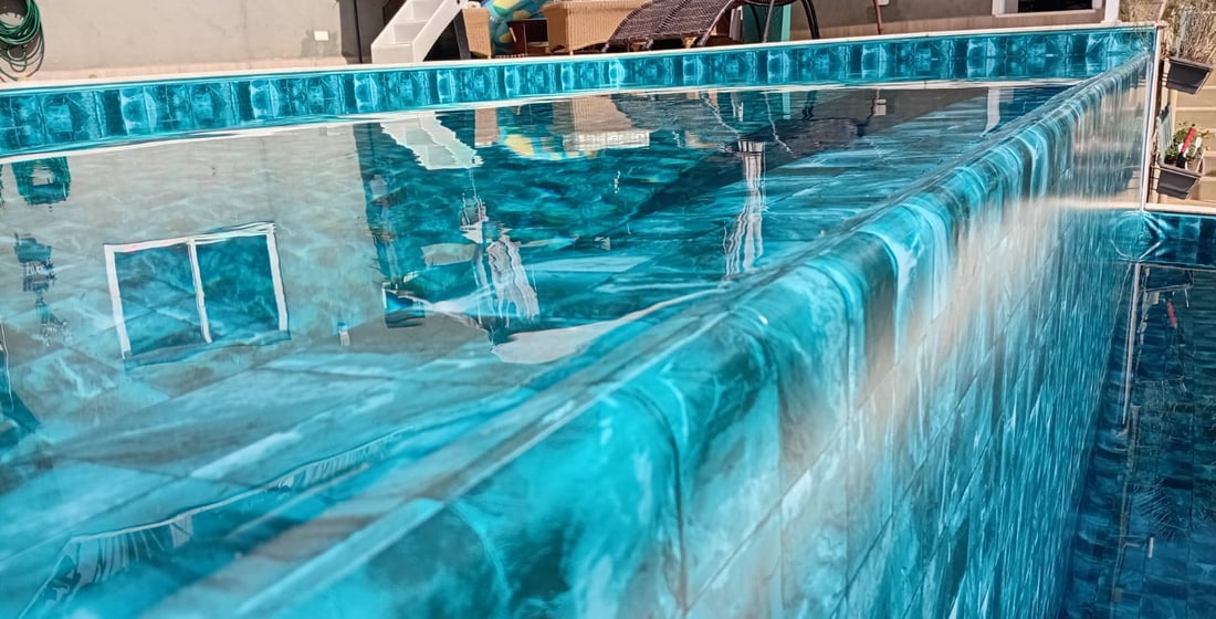 Piscina de vinil com água em tom esmeralda mostrando o efeito da estampa