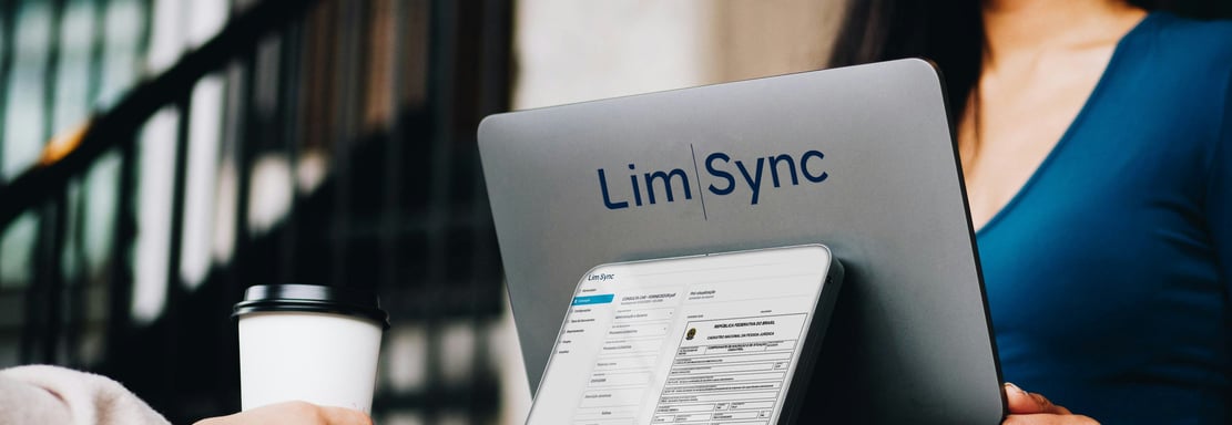 a woman sitting at a table with a laptop and a coffee cup