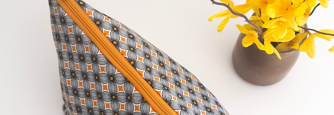 a small zippered pouchel bag with a yellow flower