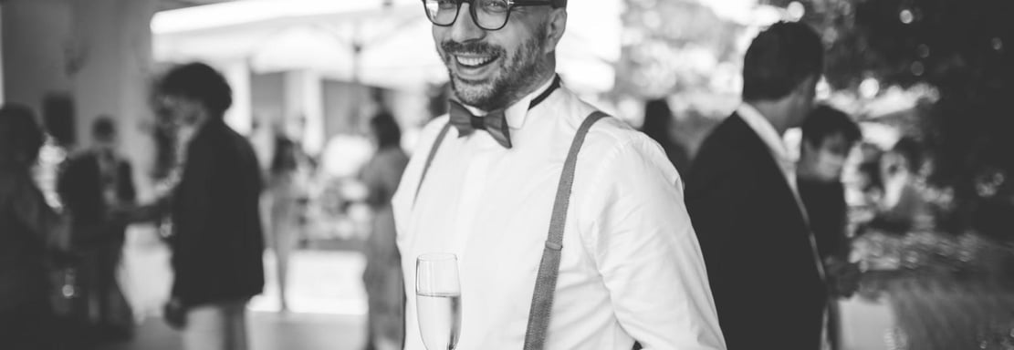 a man in a suit and bow tie smiling