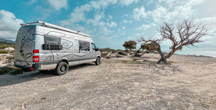 a van parked on a rocky beach
