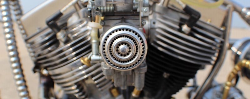 a motorcycle with a hand-built engine in the background
