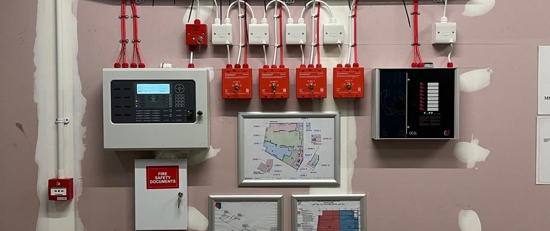 a room with a wall mounted with electrical equipment