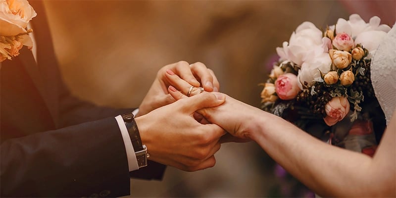 a bride and groom holding hands in a wedding ceremony