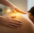 Reiki practitioner giving an energy healing session on a client’s back
