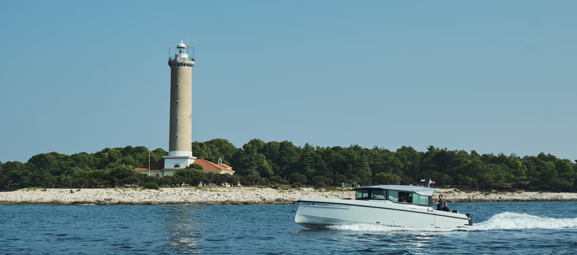 Just enjoy boat cruising the waves, passing by a lighthouse on the shore.