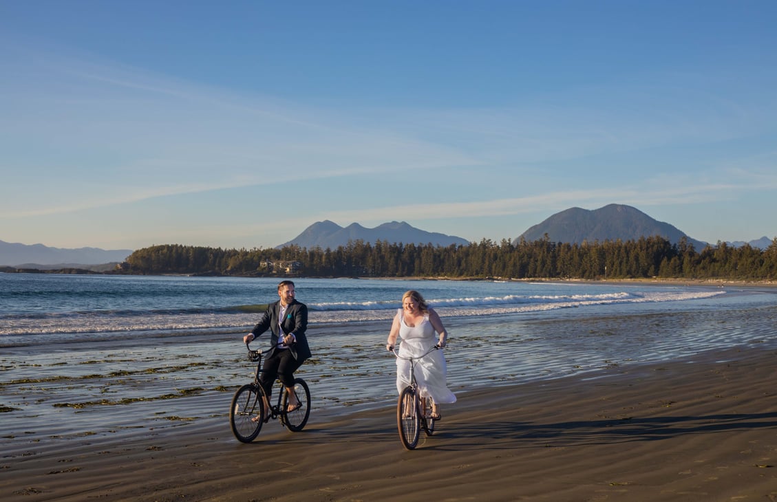 Tofino elopement photographer photographing the bride and groom on bikes