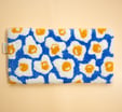 a blue and white toiletry bag with a blue and yellow flower pattern