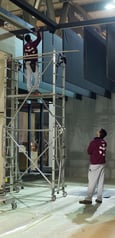 a man standing on a scaffold in a building